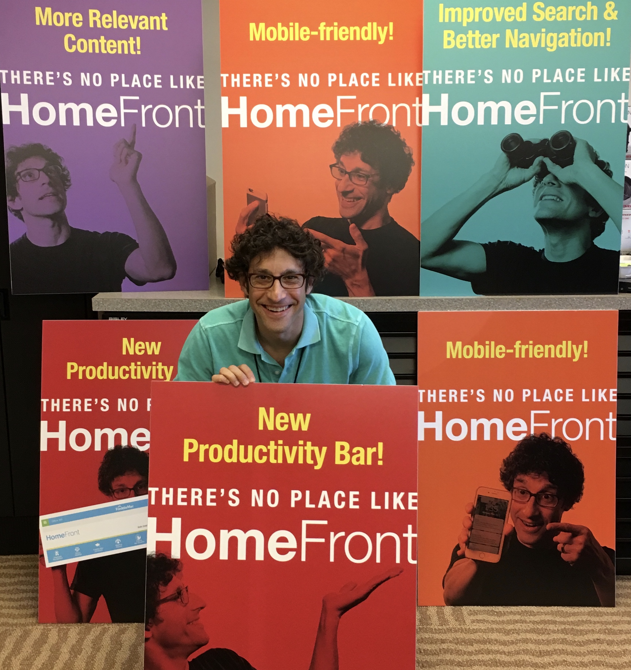 man in green shirt standing in front of a series of colored posters advertising HomeFront